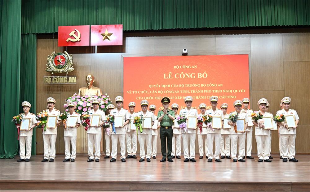 Bộ trưởng Lương Tam Quang trao Quyết định và tặng hoa chúc mừng 23 đồng chí Giám đốc Công an địa phương.
