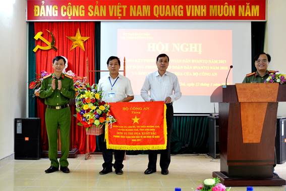 Đại tá Lê Công Bính, Phó Giám đốc Công an tỉnh Điện Biên trao Cờ thi đua của Bộ Công an cho đơn vị xuất sắc trong phong trào Toàn dân bảo vệ an ninh Tổ quốc năm 2017 tặng cán bộ và nhân dân thị trấn Mường Chà, huyện Mường Chà.