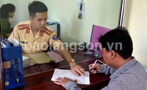 Cảnh sát giao thông Công an huyện Cao Lộc, tỉnh Lạng Sơn hướng dẫn người dân làm thủ tục hành chính.