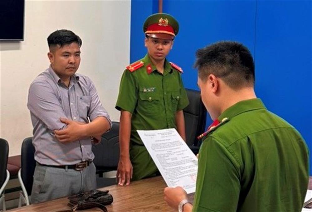 Phạm Trung Dũng (áo xám) tại cơ quan Công an.