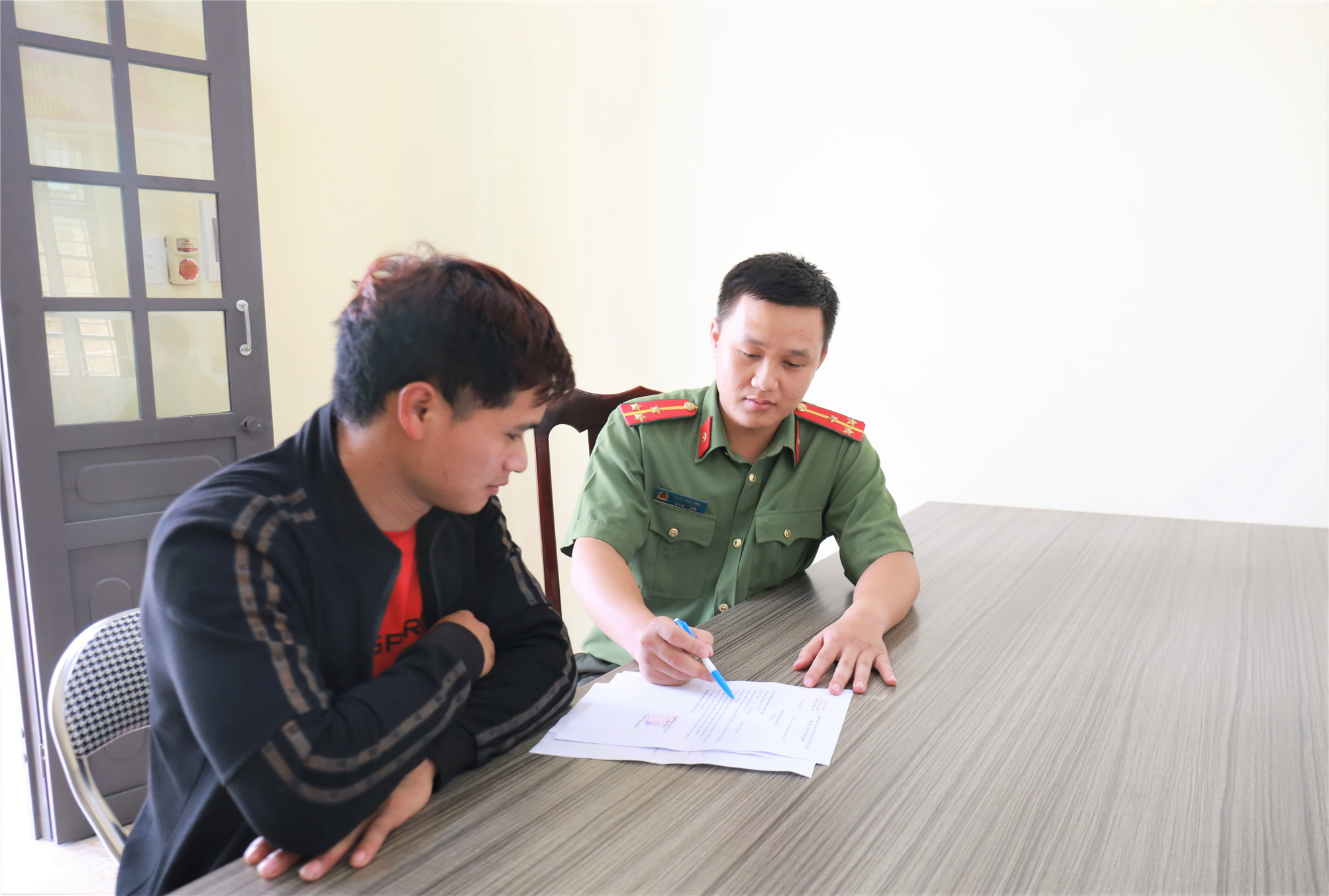 Thượng úy Đàm Văn Tiến hướng dẫn người dân về thủ tục hành chính.