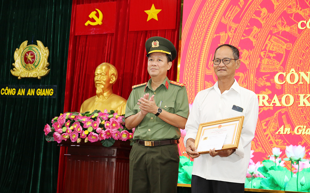 Đại tá Lê Phú Thạnh, Phó Giám đốc Công an tỉnh An Giang trao Giấy khen tặng ông Bùi Ngọc Thọ (người đã phát hiện truy hô cứu cháu bé).