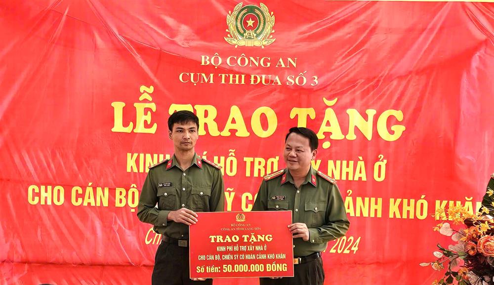 Lãnh đạo Công an tỉnh trao biển biểu trưng kinh phí hỗ trợ của Công an tỉnh cho đồng chí Lô Quốc Vĩnh.