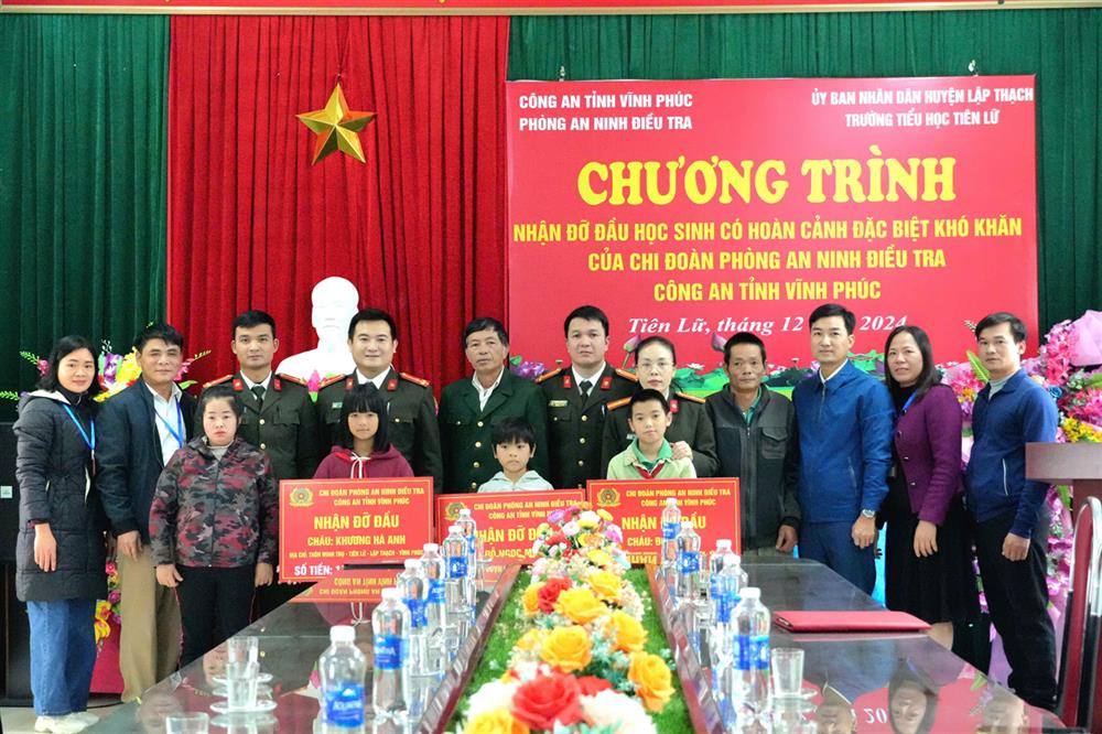 2. Lãnh đạo Phòng An ninh điều tra Công an tỉnh trao các phần quà tặng đại diện gia đình và 03 em học sinh cho hoàn cảnh đặc biệt khó khăn tại trường Tiểu học Tiên Lữ.