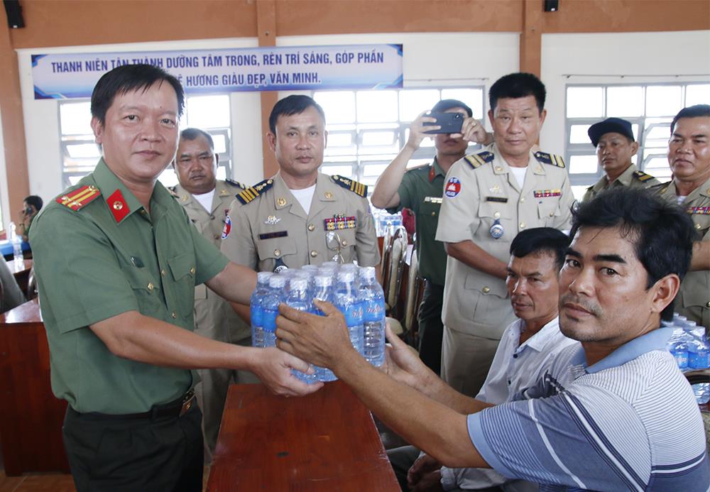 Lãnh đạo Phòng Hậu cần Công an tỉnh An Giang  trao nước uống tặng người dân.