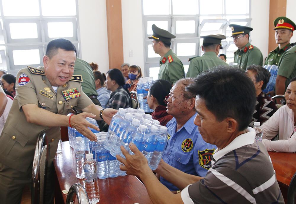 Thiếu tướng Top Sovan, Phó Giám đốc Công an tỉnh Kandal trao nước uống tặng người dân.