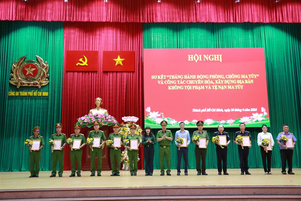 Thiếu tướng Mai Hoàng, Phó Giám đốc CATP và bà Phạm Thị Hồng Hà - Phó trưởng Ban Nội chính Thành ủy trao Thư khen của Giám đốc CATP và tặng hoa chúc mừng các tập thể có thành tích xuất sắc.