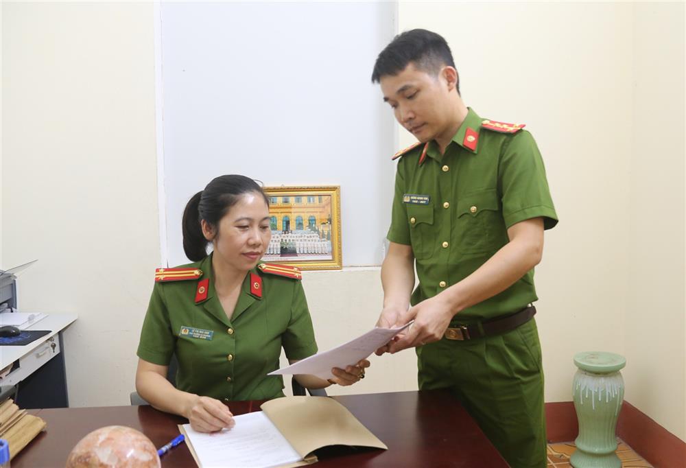 Trung tá Lê Thị Mai Anh trao đổi công việc với cán bộ trong đơn vị.
