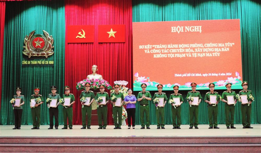 Thiếu tướng Mai Hoàng, Phó Giám đốc CATP và bà Huỳnh Thị Ngọc Hoa, Phó Viện trưởng Viện Kiểm sát nhân dân TP trao Thư khen của Giám đốc CATP và tặng hoa chúc mừng các tập thể có thành tích xuất sắc.
