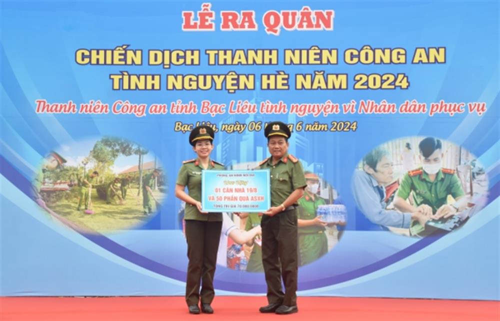 Đại diện lãnh đạo các đơn vị trao bảng tượng trưng 01 căn nhà và 50 phần quà.