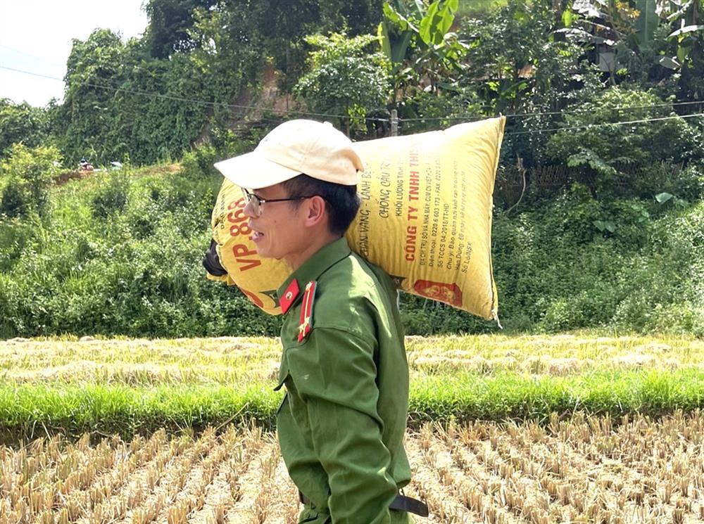 Lực lượng Công an xã cùng với đoàn viên thanh niên xuống đồng hỗ trợ bà Nông Thị Phiên thu hoạch lúa.