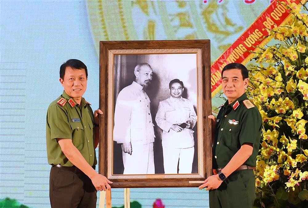 Thay mặt Quân ủy Trung ương, Bộ Quốc phòng, Bộ trưởng Phan Văn Giang trao bức ảnh lưu niệm tặng Đảng ủy Công an Trung ương, Bộ Công an.