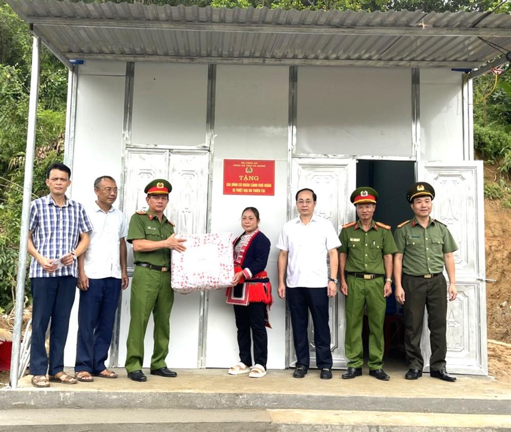 Đại diện lãnh đạo Công an tỉnh Hà Giang và lãnh đạo huyện Bắc Quang trao nhà tặng gia đình bà Triệu Mùi Viện.