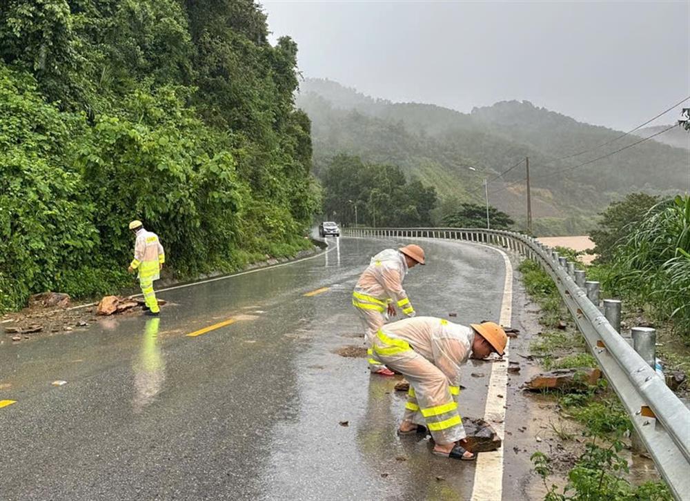 Lực lượng CSGT dọn dẹp đất đá rơi từ vách núi trên tuyến Quốc lộ 8, đoạn qua xã Sơn Kim 1, huyện Hương Sơn.