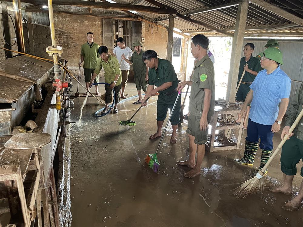 Lực lượng tham gia bảo vệ an ninh trật tự ở cơ sở huyện Lục Ngạn hỗ trợ dọn dẹp gia đình người dân sau bão.