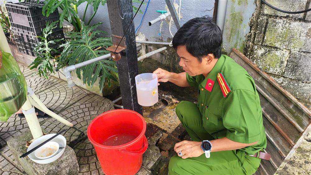 Cán bộ Công an tiến hành thu giữ mẫu nước xả thải ra môi trường của các nhà hàng để kiểm định.