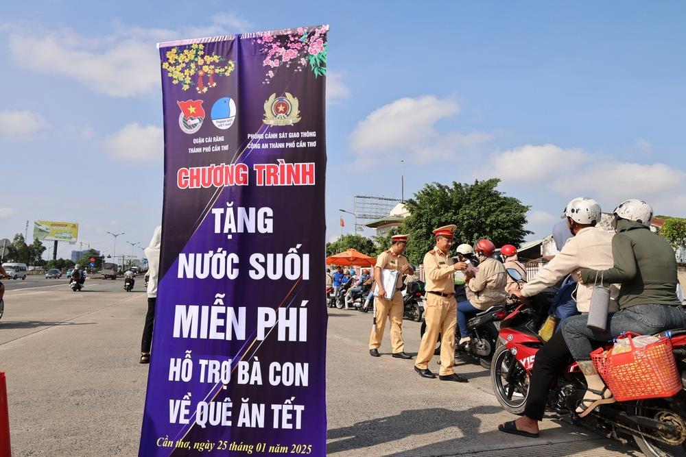 Lực lượng Cảnh sát giao thông, Công an thành phố Cần Thơ tặng nước suối, phát tờ rơi tuyên truyền Luật Trật tự, an toàn giao thông đường bộ và Nghị định 168 cho người dân trên đường về quê đón Tết.