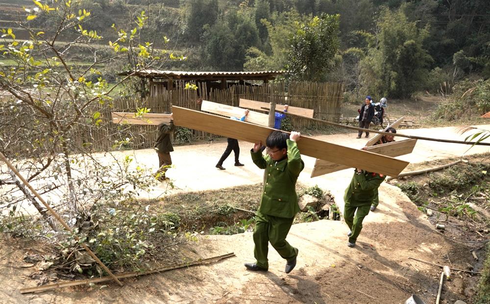 Công an xã Ca Thành giúp người dân vận chuyển nguyên vật liệu để làm nhà.