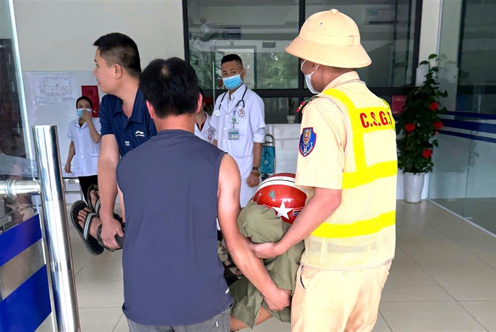 Cán bộ CSGT hỗ trợ đưa anh Tr.V.T. đi cấp cứu.