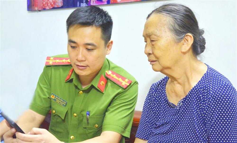 Cán bộ Công an phường Võ Cường, thành phố Bắc Ninh hướng dẫn người dân khu phố Bồ Sơn góp ý vào Dự thảo sửa đổi, bổ sung Hiến pháp năm 2013 qua ứng dụng nền tảng số VNeID.