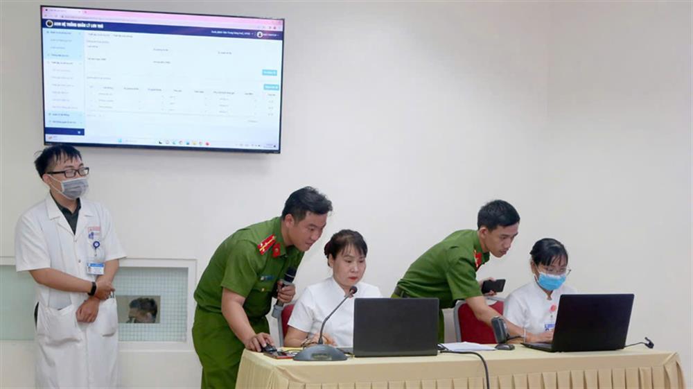 Thượng úy Đinh Viết Lợi (bên trái) tuyên truyền về những quy định, tiện ích của ứng dụng định danh và xác thực điện tử tại Bệnh viện Trung ương Huế.