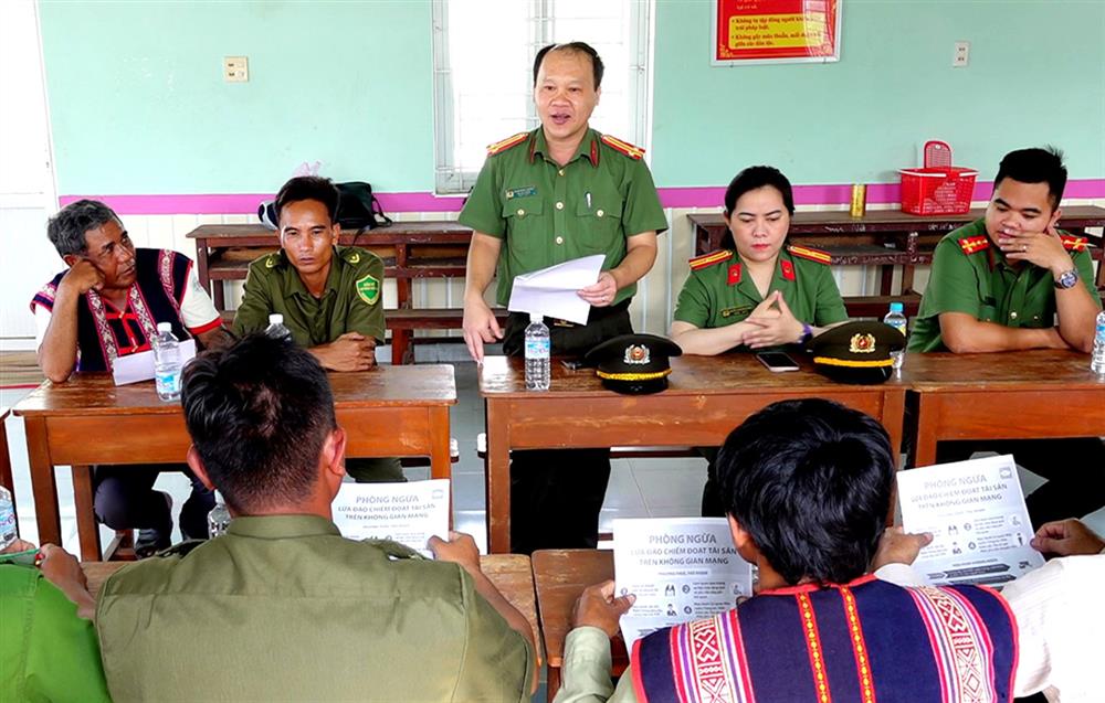 Cán bộ, chiến sĩ Công an tỉnh Bình Định tuyên truyền về tội phạm lừa đảo trên không gian mạng cho Ban quản lý làng Cà Sim, xã Canh Thuận, huyện Vân Canh.