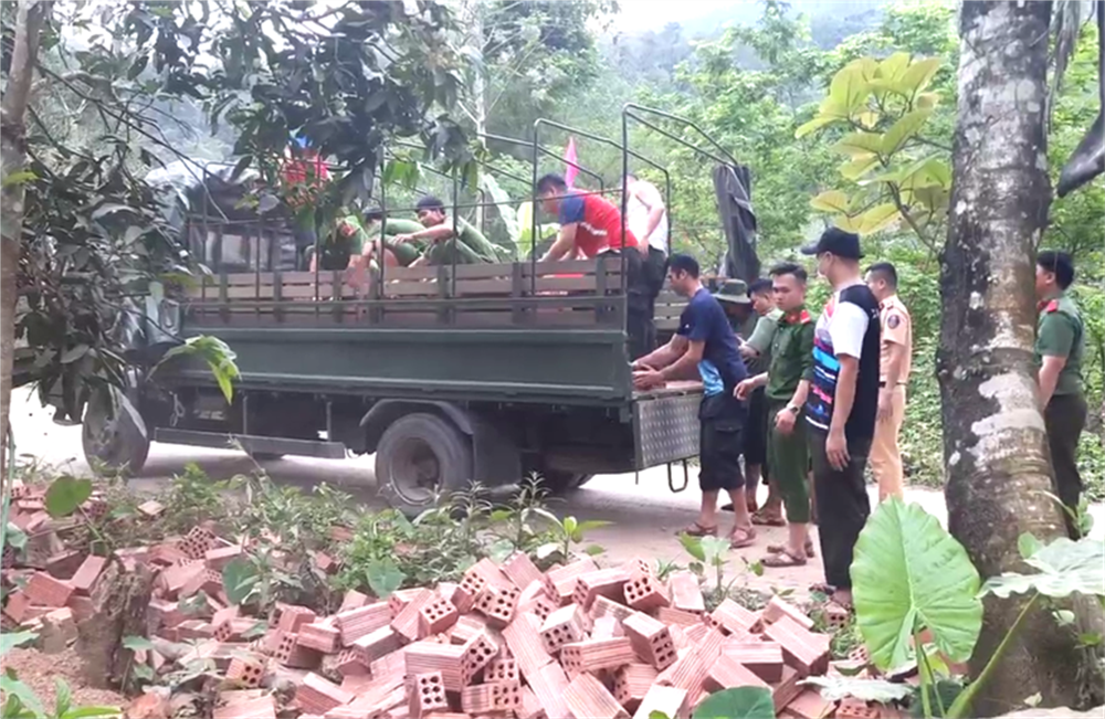 Cán bộ, chiến sĩ vận chuyển nguyên vật liệu hỗ trợ các hộ có hoàn cảnh khó khăn xây dựng nhà mới.