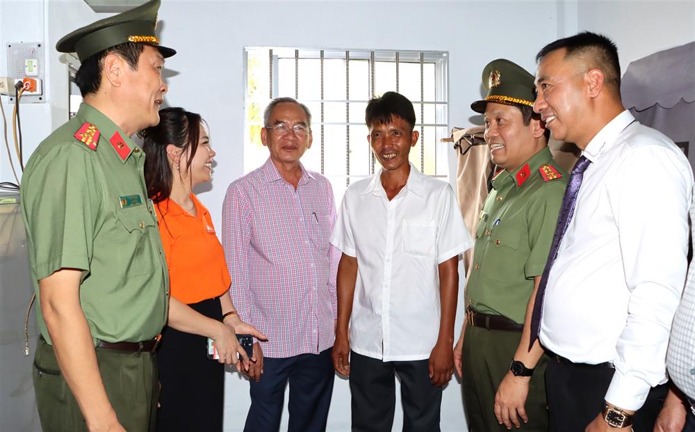 Anh Nguyễn Văn Bi (thứ 3 từ phải sang) phấn khởi dẫn các đại biểu tham quan căn nhà mới được Bộ Công an trao tặng.