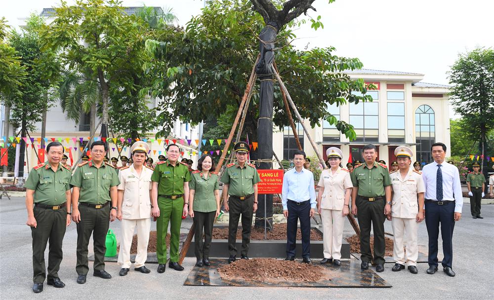 Thứ trưởng Lê Quốc Hùng cùng các đại biểu trong cây lưu niệm trong khuôn viên Nhà trường.