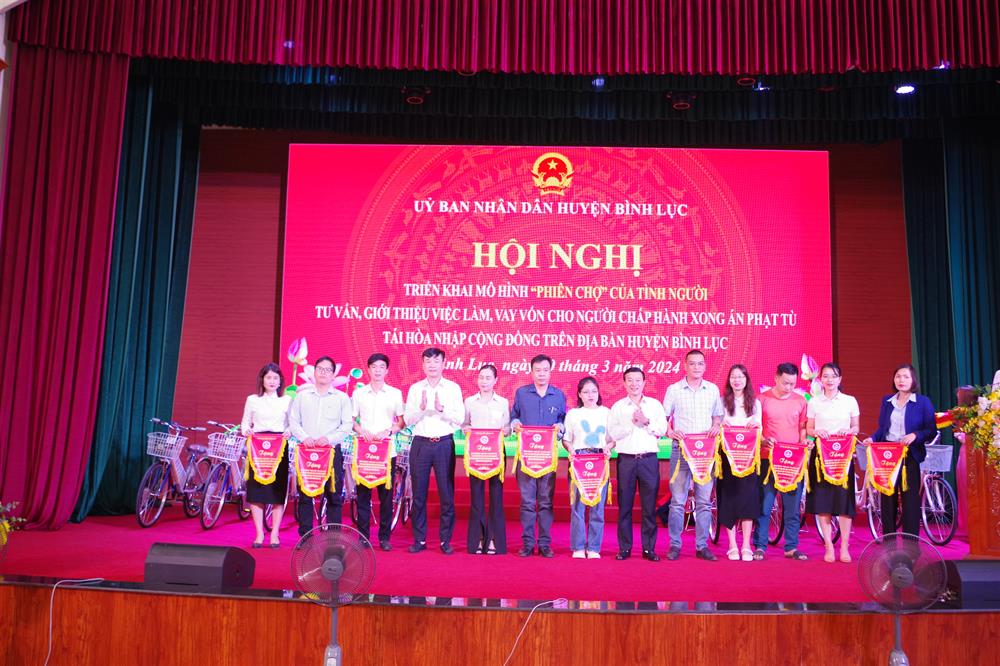 Lãnh đạo huyện ủy, UBND huyện Bình Lục trao Cờ lưu niệm cho các đơn vị tham gia phiên tư vấn giới thiệu việc làm cho người chấp hành xong án phạt tù.