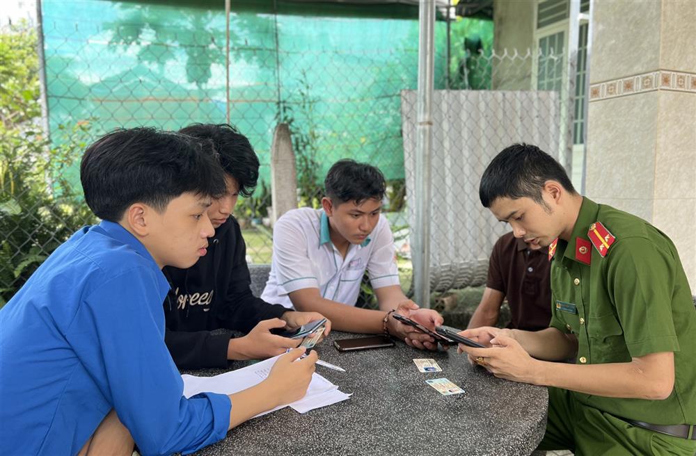 Công an xã Trà Tân đến nhà người dân hướng dẫn kích hoạt mã định danh điện tử VNeID cấp độ 2.
