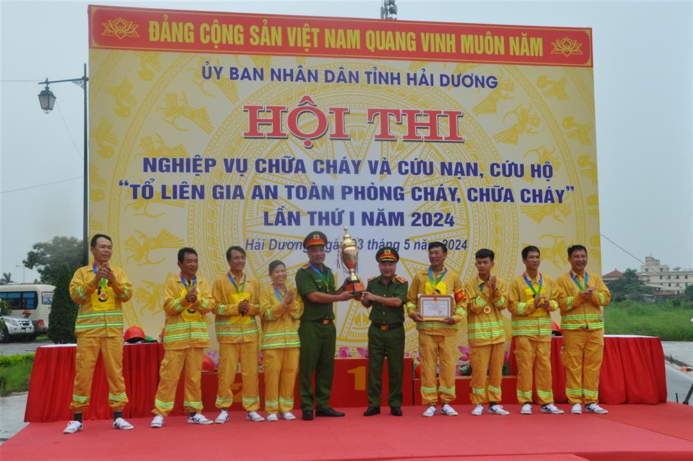 Thiếu tướng Nguyễn Đình Hoàn, Phó Cục Trưởng Cục Cảnh sát PCCC và CNCH Bộ Công an trao giải Nhất và Cúp vô địch cho Đội thi Tổ liên gia an toàn PCCC xã Chi Lăng Nam, huyện Thanh Miện.