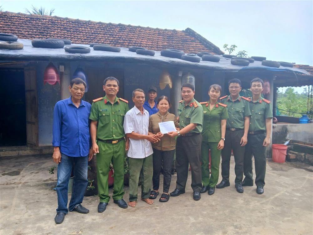 Lãnh đạo Công an thị xã Đông Hòa tặng quà cho các hộ dân có nhà bị tốc mái do lốc xoáy gây ra.