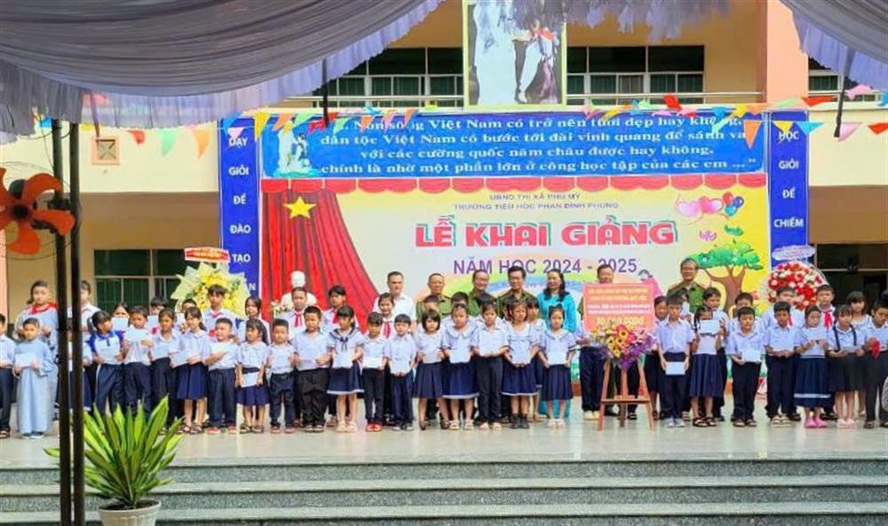 Đoàn trao quà tặng các em học sinh có hoàn cảnh khó khăn.