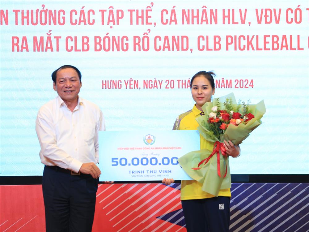 Đồng chí Nguyễn Văn Hùng trao phần thưởng của Hiệp hội Thể thao CAND Việt Nam tặng VĐV Trịnh Thu Vinh. 