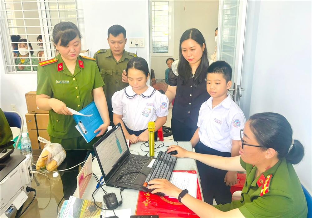 Thiếu tá Bùi Thuận Thảo Linh hỗ trợ các em học sinh làm căn cước.
