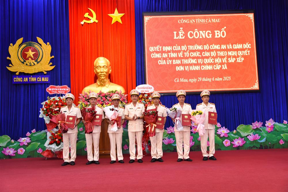 Đại tá Hồ Việt Triều trao quyết định, tặng hoa các đồng chí Phó Giám đốc Công an tỉnh.