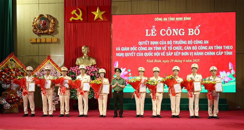 Đại tá Nguyễn Hữu Mạnh, Giám đốc Công an tỉnh trao quyết định, tặng hoa chúc mừng 30 đồng chí Trưởng phòng được bố trí khi sáp nhập.