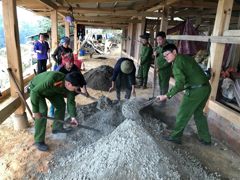 Công an xã Dế Xu Phình, huyện Mù Cang Chải giúp người dân làm nền nhà.