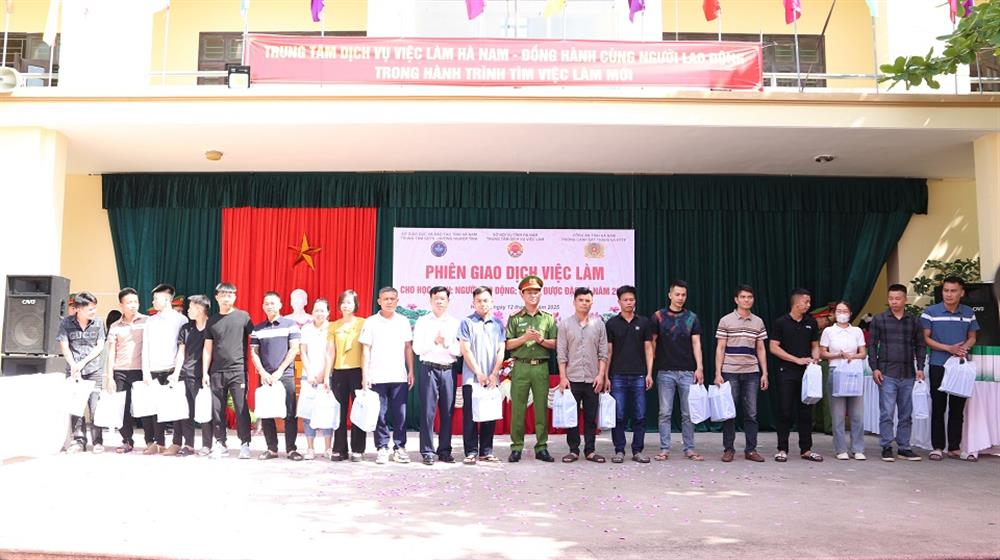 Đại tá Phạm Hùng Dương và đồng chí Nguyễn Xuân Thông, Giám đốc Bảo hiểm nhân thọ tỉnh trao quà cho người được đặc xá.