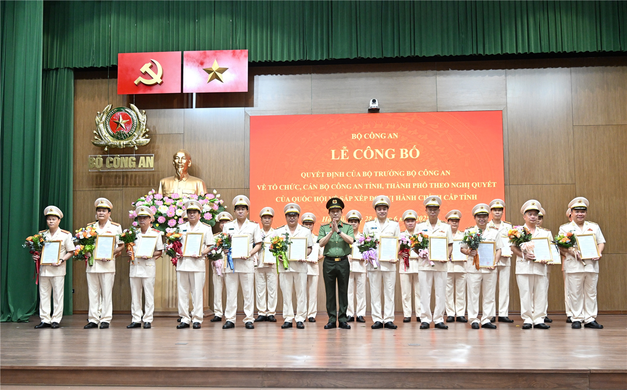 Bộ trưởng Lương Tam Quang trao Quyết định và tặng hoa chúc mừng 23 đồng chí Giám đốc Công an địa phương.