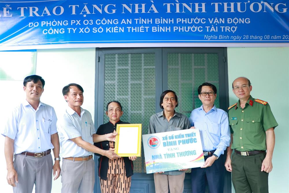 Đại diện Phòng Công tác Đảng và công tác chính trị Công an tỉnh Bình Phước và UBND xã Nghĩa Bình trao quyết định bàn giao nhà cho hộ gia đình ông Đoàn Văn Huyện.