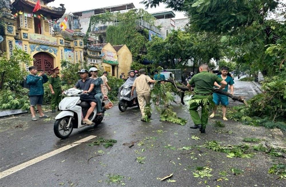 Công an Hà Nội thu dọn cây đổ giúp người dân đi lại thuận lợi.