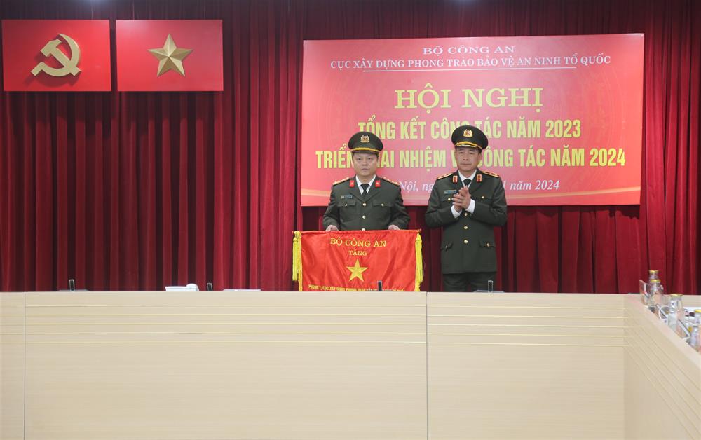 Thứ trưởng Lê Quốc Hùng trao Cờ thi đua của Bộ Công an cho Phòng 1, Cục Xây dựng phong trào bảo vệ ANTQ.