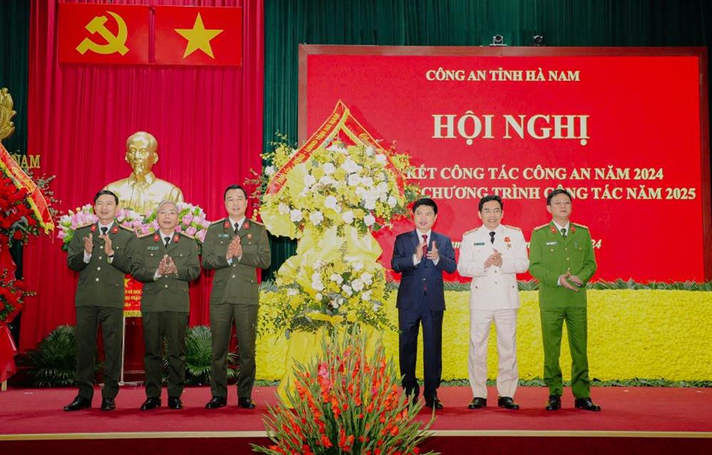 Thay mặt Tỉnh ủy, HĐND, UBND tỉnh, đồng chí Trương Quốc Huy - Phó Bí thư Tỉnh ủy, Chủ tịch Uỷ ban nhân dân tỉnh, Trưởng Đoàn đại biểu Quốc hội tỉnh Hà Nam tặng hoa chúc mừng Công an Hà Nam.     