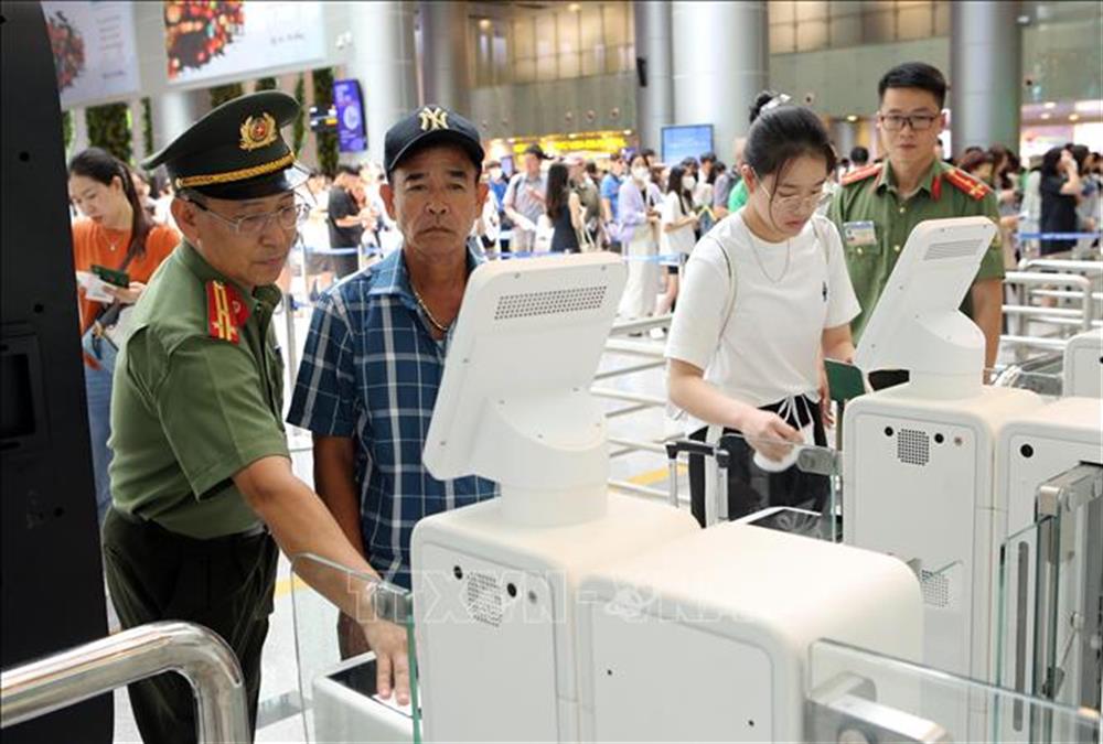  Lực lượng Công an hướng dẫn hành khách sử dụng hệ thống Cổng kiểm soát xuất nhập cảnh tự động.