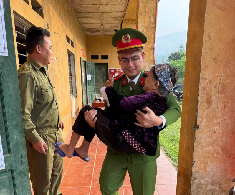 Công an xã Văn Miếu hỗ trợ cụ bà cao tuổi tham gia bỏ phiếu.jpg