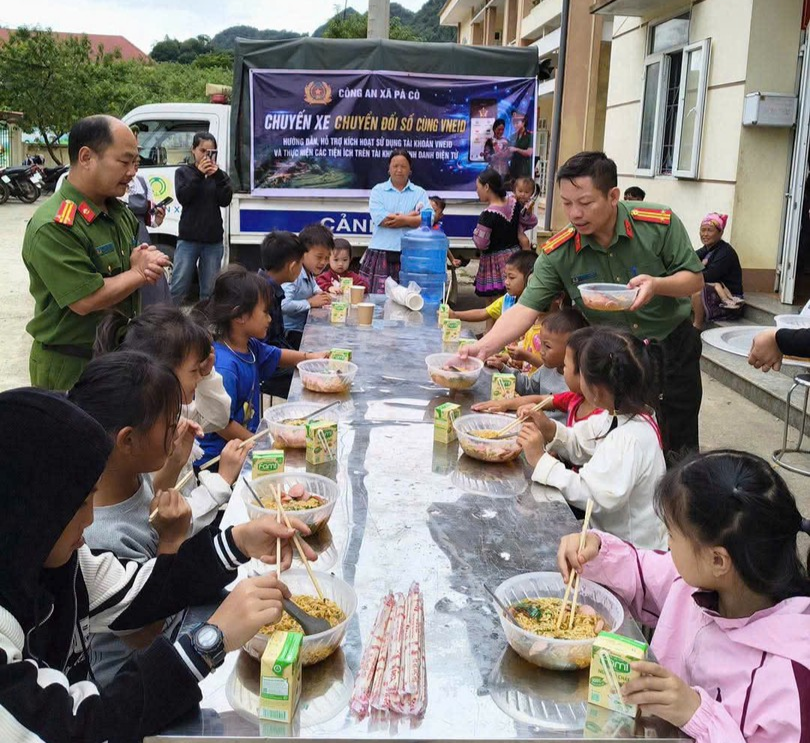 Cán bộ Công an xã Pà Có phục vụ mỳ tôm cho các cháu thiếu nhi.jpg