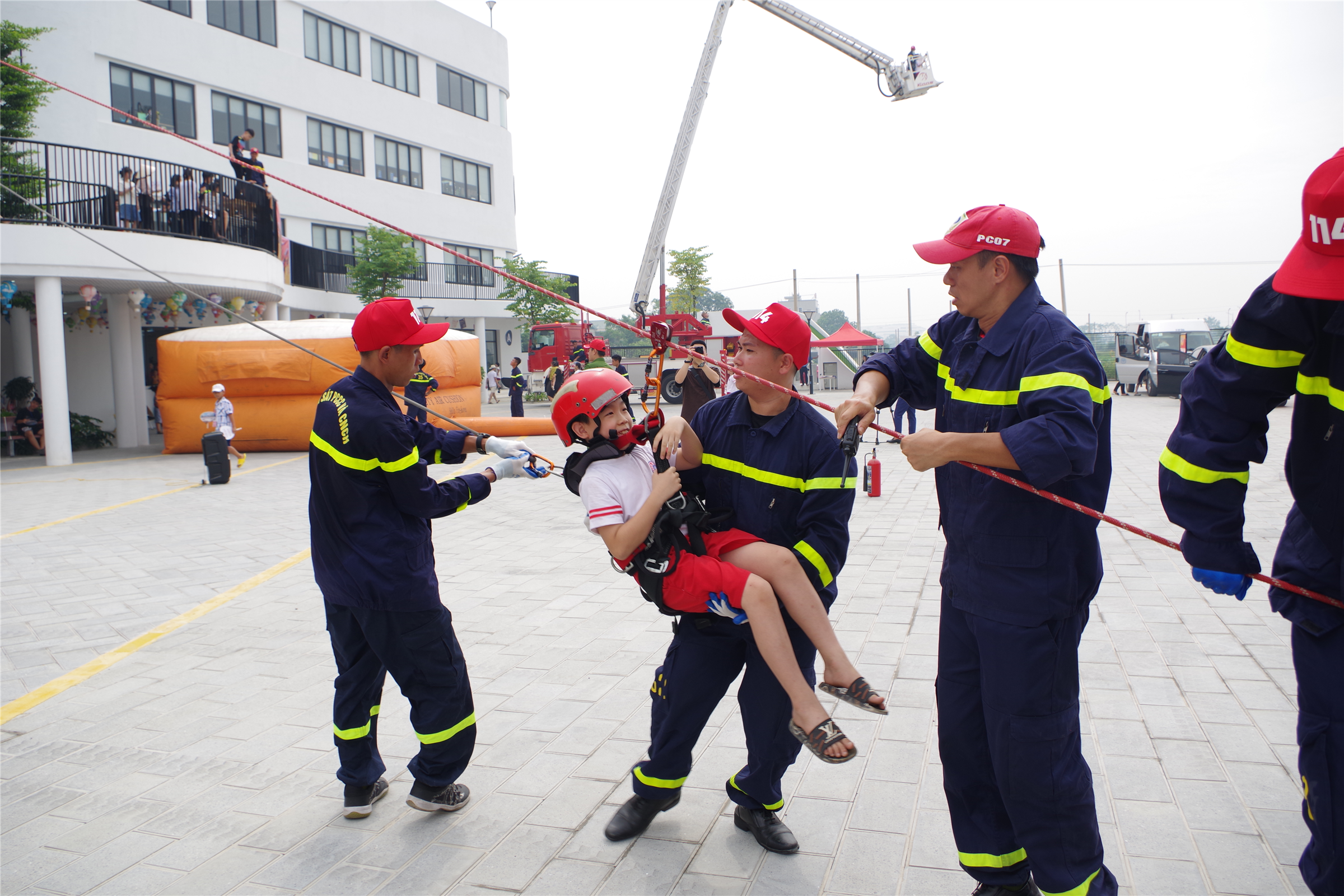Các em học sinh trường Tiểu học, THCS và THPT Mensa thực hành trải nghiệm kỹ năng thoát nạn bằng cầu dây nghiêng, đệm hơi