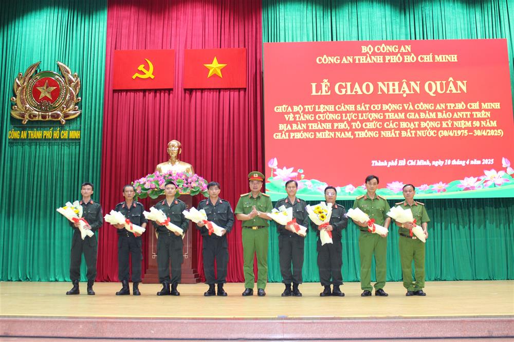 Đại tá Nguyễn Đình Dương, Phó Giám đốc CATP động viên, tặng hoa đại diện cán bộ, chiến sĩ được tăng cường đảm bảo an ninh, trật tự.